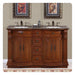 Elegant wooden bathroom vanity with granite countertop, two sinks, ornate framed urn artwork, and decorative bathroom accessories.
