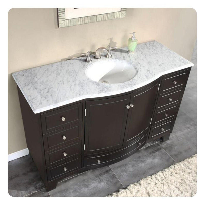 Dark wood bathroom vanity with white marble countertop, integrated sink, and decorative drawer pulls