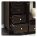 Dark wood file cabinet with three open drawers, silver round knobs, and decorative ceramic vase on adjacent surface