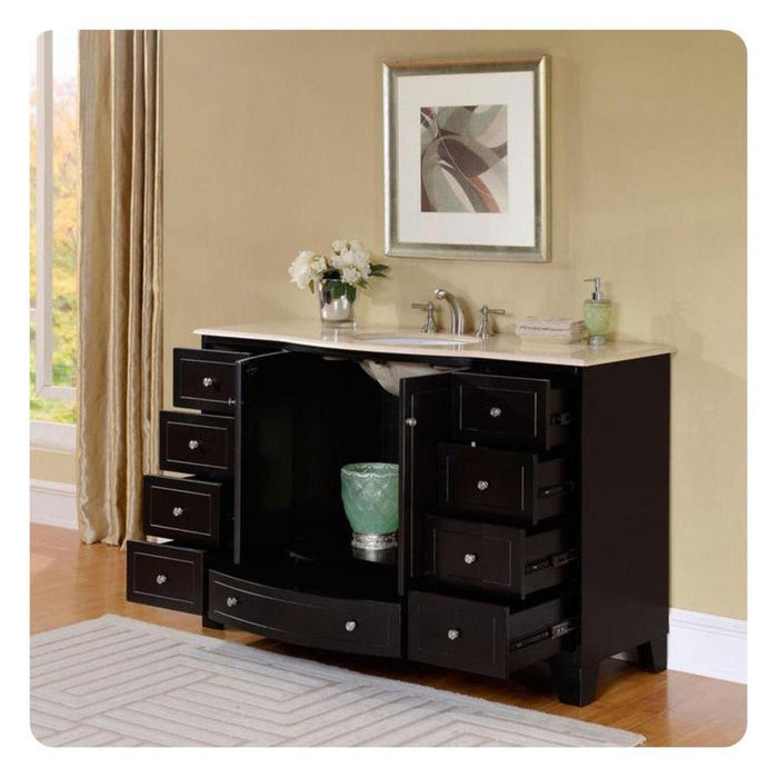 Black bathroom vanity with multiple open drawers, white marble top, silver faucet, and white flowers in a vase beside a framed abstract artwork.