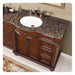 Elegant wooden bathroom vanity with Baltic brown granite countertop, white sink, and ornate carved details.