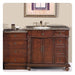 Elegant wooden bathroom vanity with dark granite top, multiple drawers, central cabinet, and oval sink with bronze faucet fixtures.