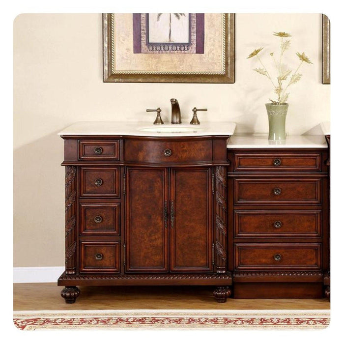 Elegant wooden bathroom vanity with rich brown finish, white marble top, multiple drawers, and center cabinet with decorative hardware.
