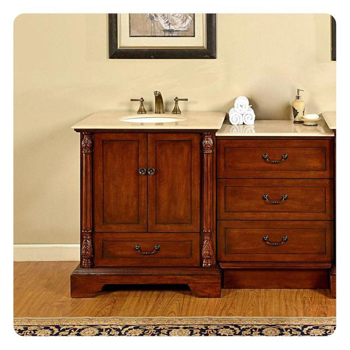 Elegant wooden bathroom vanity with marble top, decorative columns, rolled white towels, and bronze fixtures.