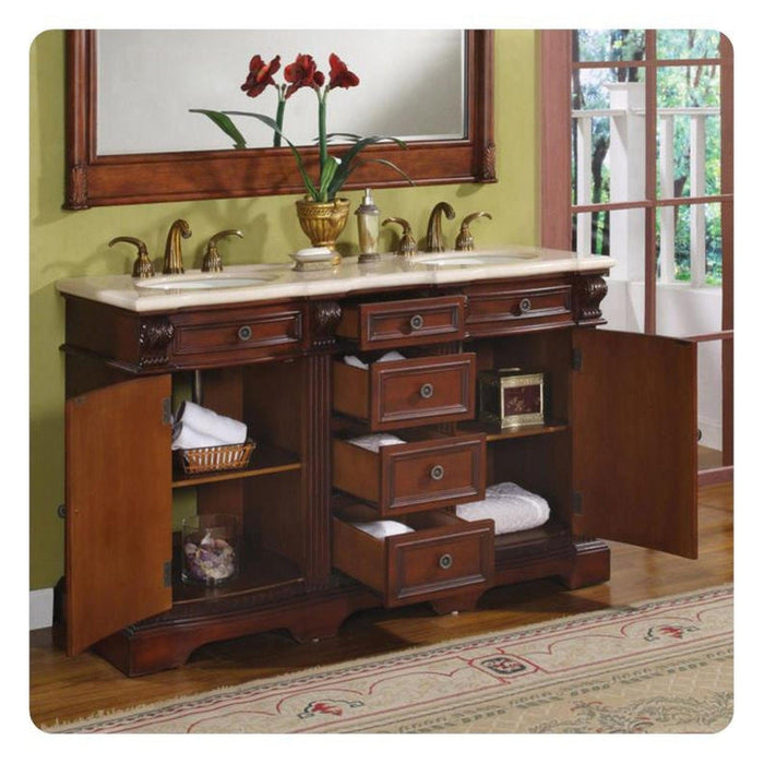 Rich cherry wood bathroom vanity with marble top, open drawers, red amaryllis flowers, and window view.