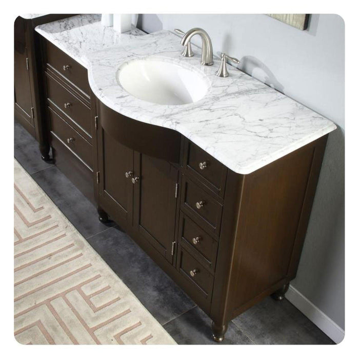 Dark wood bathroom vanity with white marble countertop, oval sink, and brushed nickel faucet fixtures.