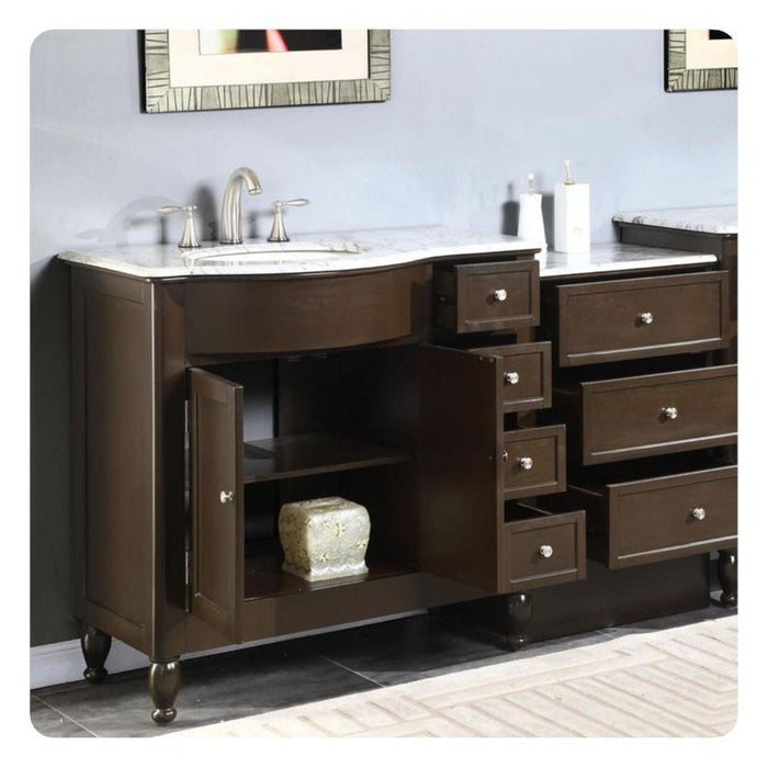 Dark wood bathroom vanity with marble top, undermount sink, and decorative hardware with open cabinet and multiple drawers