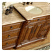 Rich wood bathroom vanity with carved details, marble countertop, and oval undermount sink with decorative accessories.