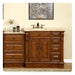 Rich wood bathroom vanity with carved details, marble top, sink, and decorative accessories on light cream wall.