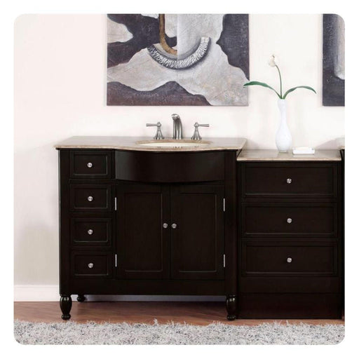 Dark wood bathroom vanity with marble top, single sink, and matching side cabinet, with abstract art and white vase with flower in background.