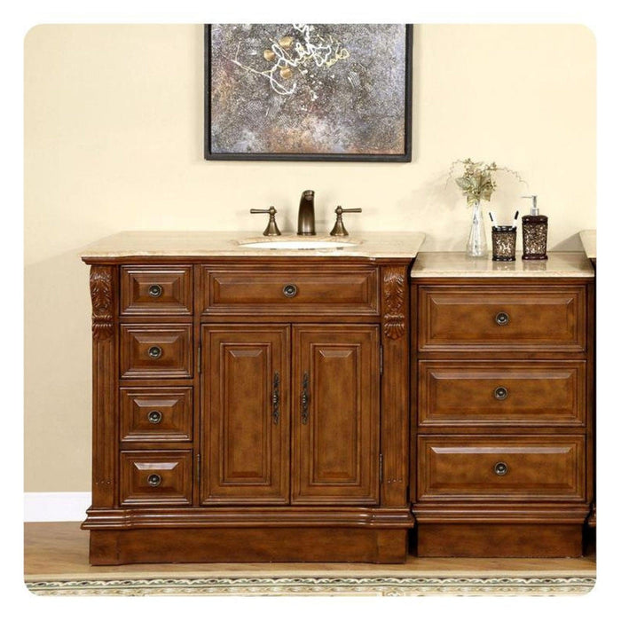 Rich wood bathroom vanity with ornate drawers, marble top sink, and decorative abstract art hanging above.
