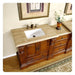 Elegant wooden bathroom vanity with marble countertop, white sink, bronze fixtures, and decorative floral vase.