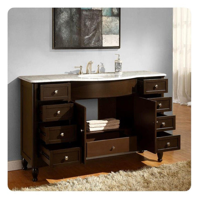 Dark wood bathroom vanity with white marble top, multiple open drawers, and sink with faucet and soap dispenser.