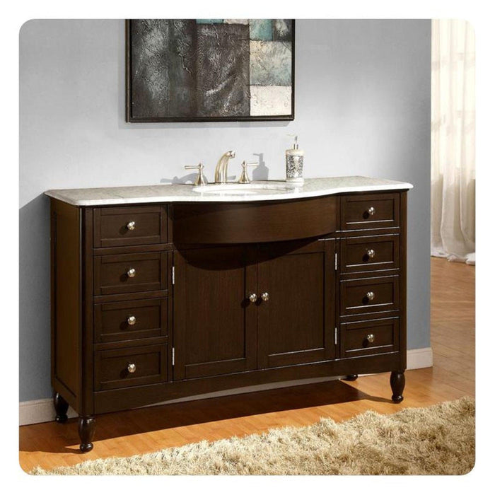 Dark wood bathroom vanity with white marble top, six drawers, center cabinet, and oval sink with silver faucet fixtures.