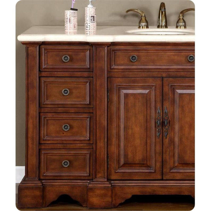 Rich wooden bathroom vanity with four drawers, cabinet doors, white marble top, and brass faucet fixtures.