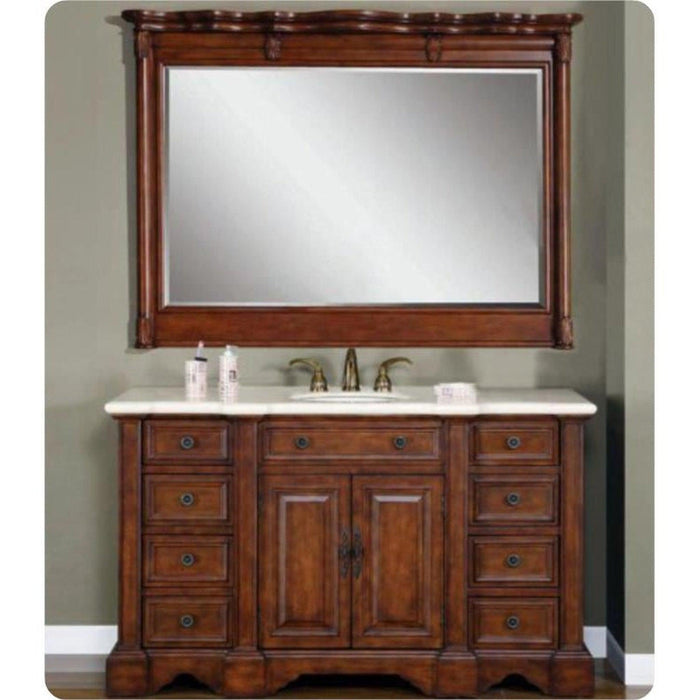 Rich wood bathroom vanity with white marble top, matching framed mirror, and antique brass fixtures