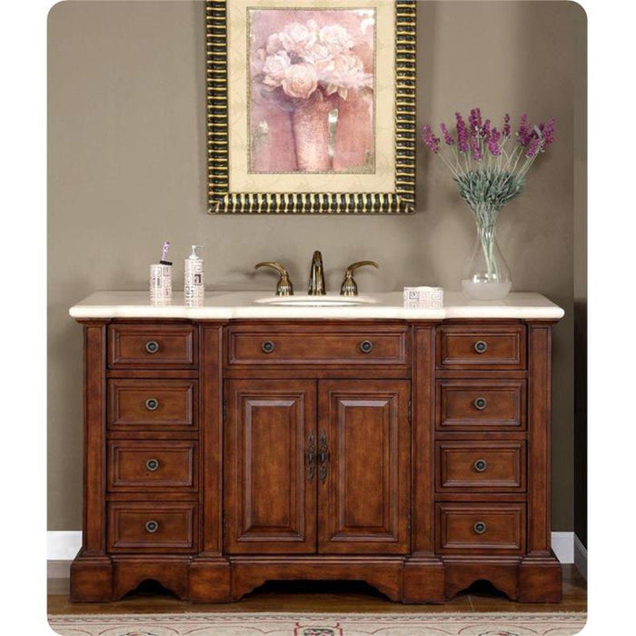Rich wood bathroom vanity with white marble top, center sink, and ornate drawers, accented by lavender flowers and floral wall art.