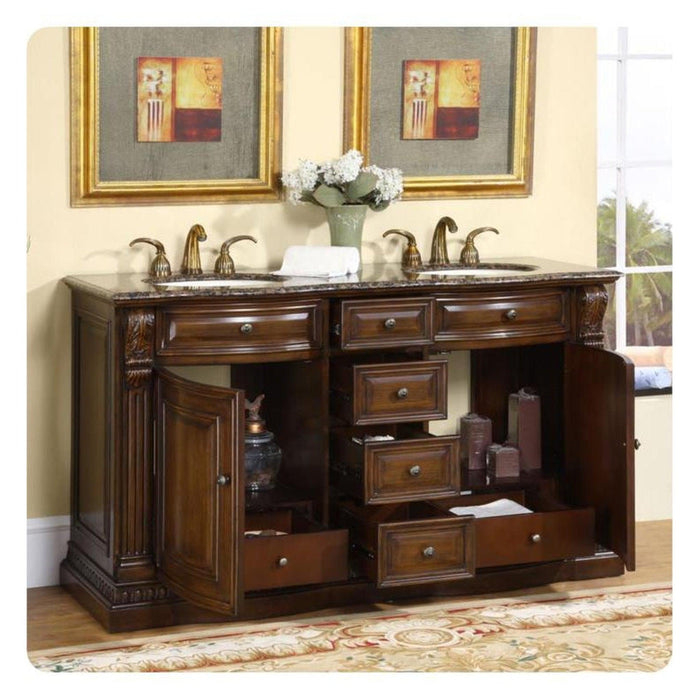 Elegant wooden bathroom vanity with marble top, double sinks, bronze faucets, multiple drawers, and floral artwork in gold frames.