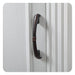 Dark bronze curved door handle on white vertical paneled surface