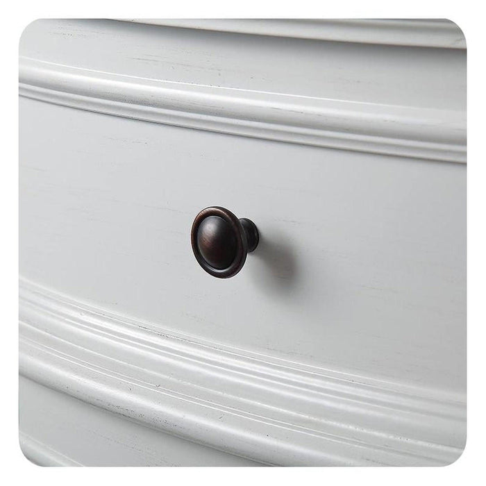 Dark bronze drawer knob on white paneled cabinet with decorative molding