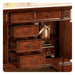 Rich mahogany dresser with multiple open drawers, ornate handles, and a decorative wrapped gift on an interior shelf.