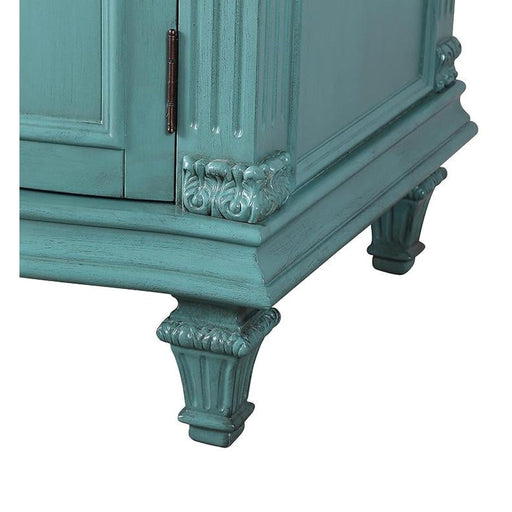 Vintage teal wooden cabinet with ornate carved legs and decorative molding, showing detailed craftsmanship and distressed finish.