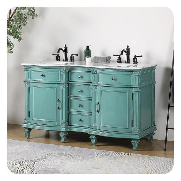 Vintage teal bathroom vanity with marble top, black faucets, and ornate carved details on legs and cabinet