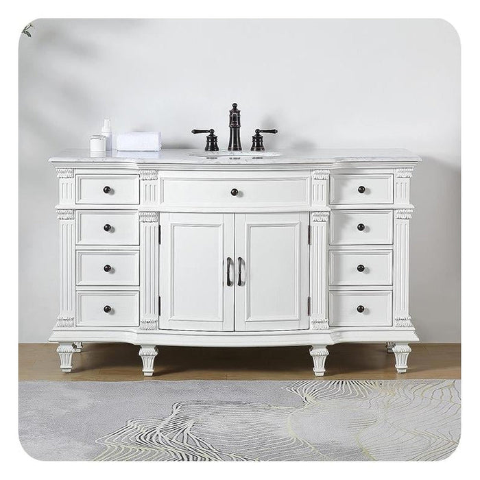 White bathroom vanity with six drawers, black hardware, marble top, and black faucet on ornate curved legs.