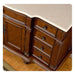Ornate wooden dresser with carved details, four drawers, and decorative handles on a hardwood floor.