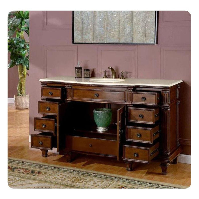 Antique wooden bathroom vanity with multiple drawers, marble top sink, and green ceramic vase, against a pink wall with decorative plant.