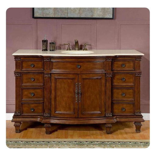 Elegant wooden bathroom vanity with curved drawers, intricate carved details, white marble top, and oval sink against dusty rose wall.