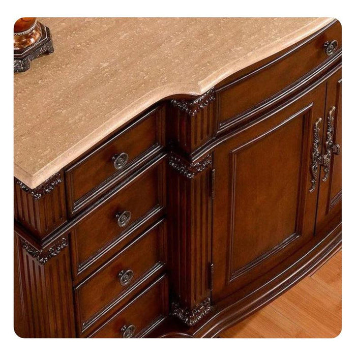 Ornate wooden dresser with curved drawers, detailed carved edges, and polished brass hardware on a light stone surface.