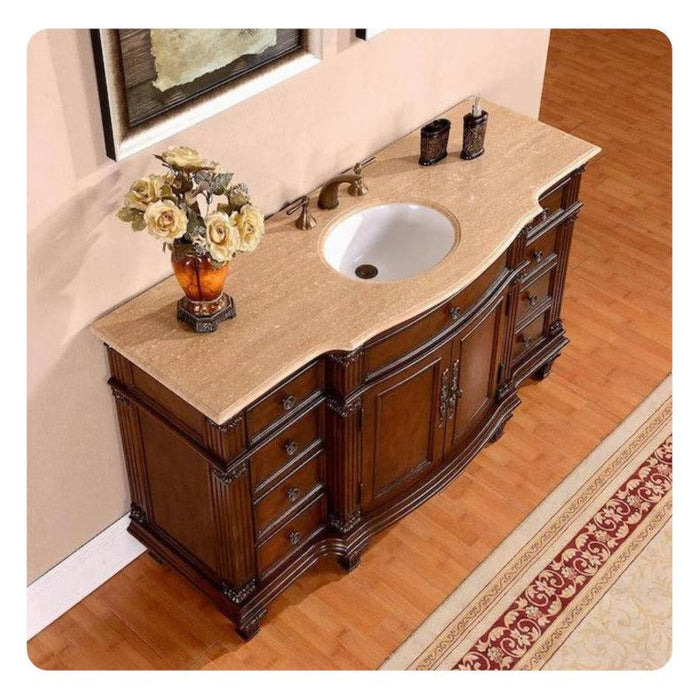 Antique wooden bathroom vanity with travertine top, white sink, ornate design, and yellow roses in decorative vase