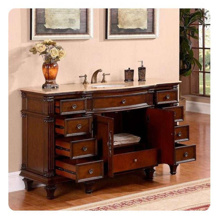 Antique wooden bathroom vanity with multiple drawers, marble countertop, sink, and decorative vase with roses, set against light walls.