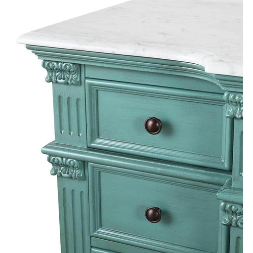 Vintage teal dresser with ornate carved details, white marble top, and dark bronze knobs, showing distressed paint finish.