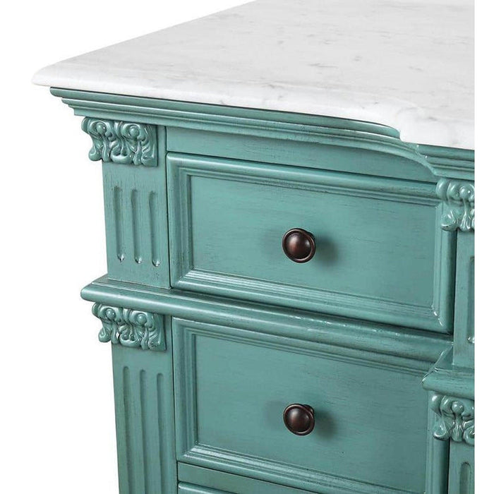 Vintage teal dresser with ornate carved details, white marble top, and dark bronze knobs, showing distressed paint finish.