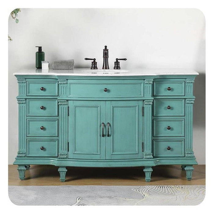 Vintage-style bathroom vanity in mint green, with ornate details, white marble top, and black fixtures.