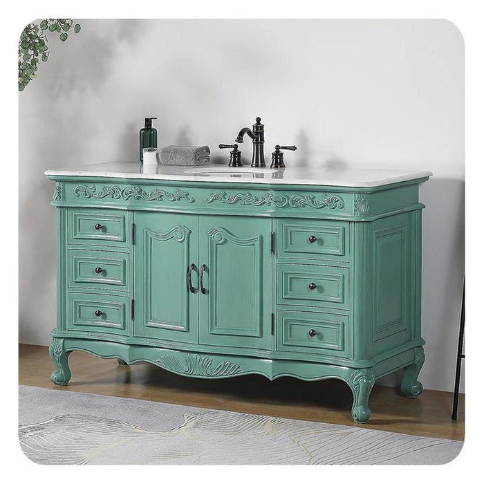 Vintage-style seafoam green bathroom vanity with ornate carved details, marble top, and black fixtures