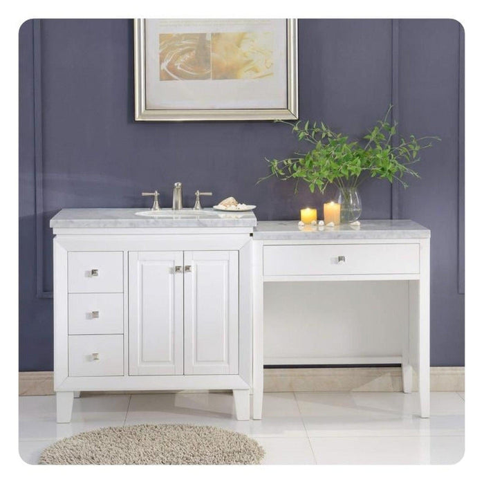 White bathroom vanity with sink, marble countertop, side cabinet, and decorative candles and green plant against dark blue wall.
