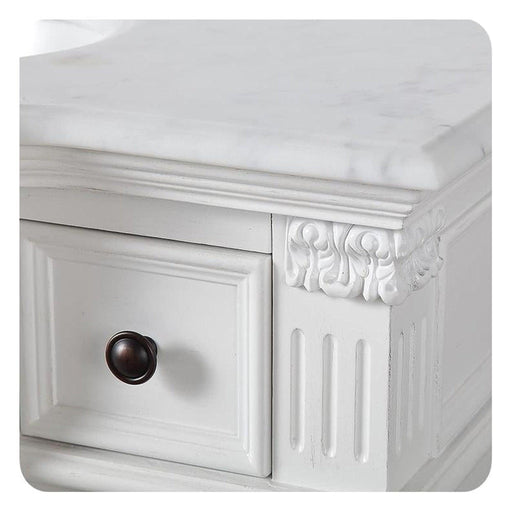White ornate drawer with dark round knob, decorative carved corner and vertical panel details