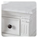 White ornate drawer with dark round knob, decorative carved corner and vertical panel details