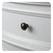 Dark bronze drawer knob on white wooden cabinet with decorative molding