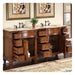 Antique wooden bathroom vanity with multiple open drawers, marble countertop, black faucets, and decorative artwork above