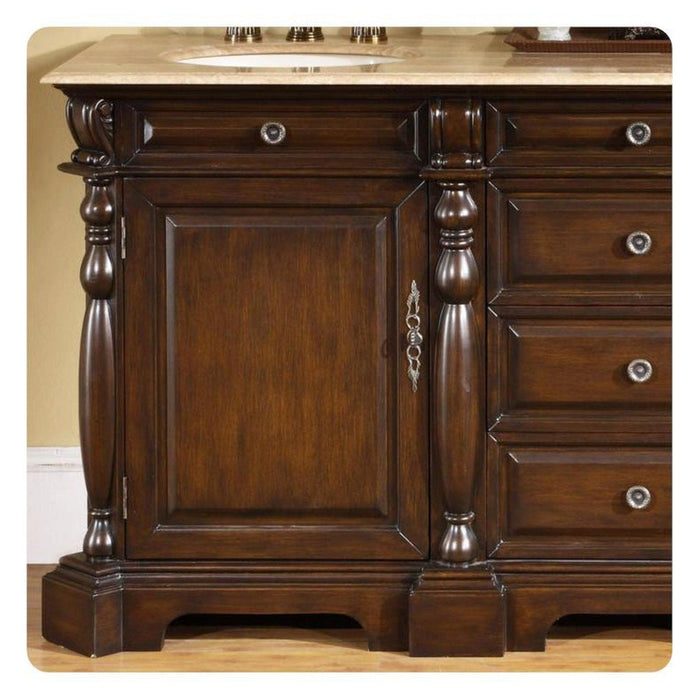Rich dark wood bathroom vanity with ornate turned columns, decorative hardware, and a marble countertop with an undermount sink.
