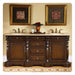 Rich wood double vanity with marble top, ornate gold-framed art, and red floral centerpiece