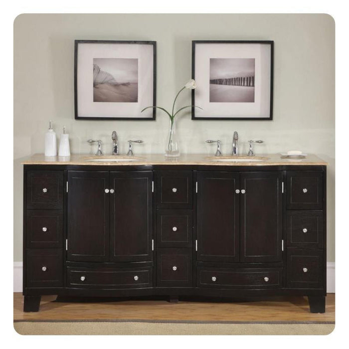 Dark wood bathroom vanity with double sinks, marble countertop, chrome fixtures, and two black-framed black and white landscape photographs above.