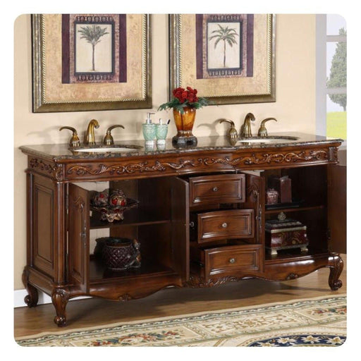 Ornate wooden bathroom vanity with marble top, double sinks, gold fixtures, and palm tree artwork above.