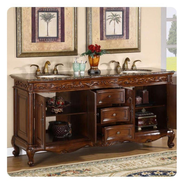 Ornate wooden bathroom vanity with marble top, double sinks, gold fixtures, and palm tree artwork above.