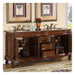 Ornate wooden bathroom vanity with marble top, double sinks, gold fixtures, and palm tree artwork above.