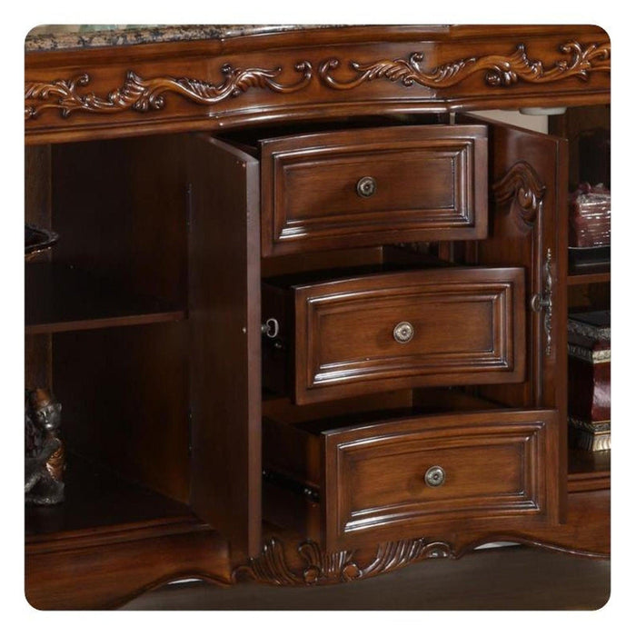 Rich wood desk with ornate carved details, three open drawers with round metal pulls, showing elegant traditional craftsmanship.